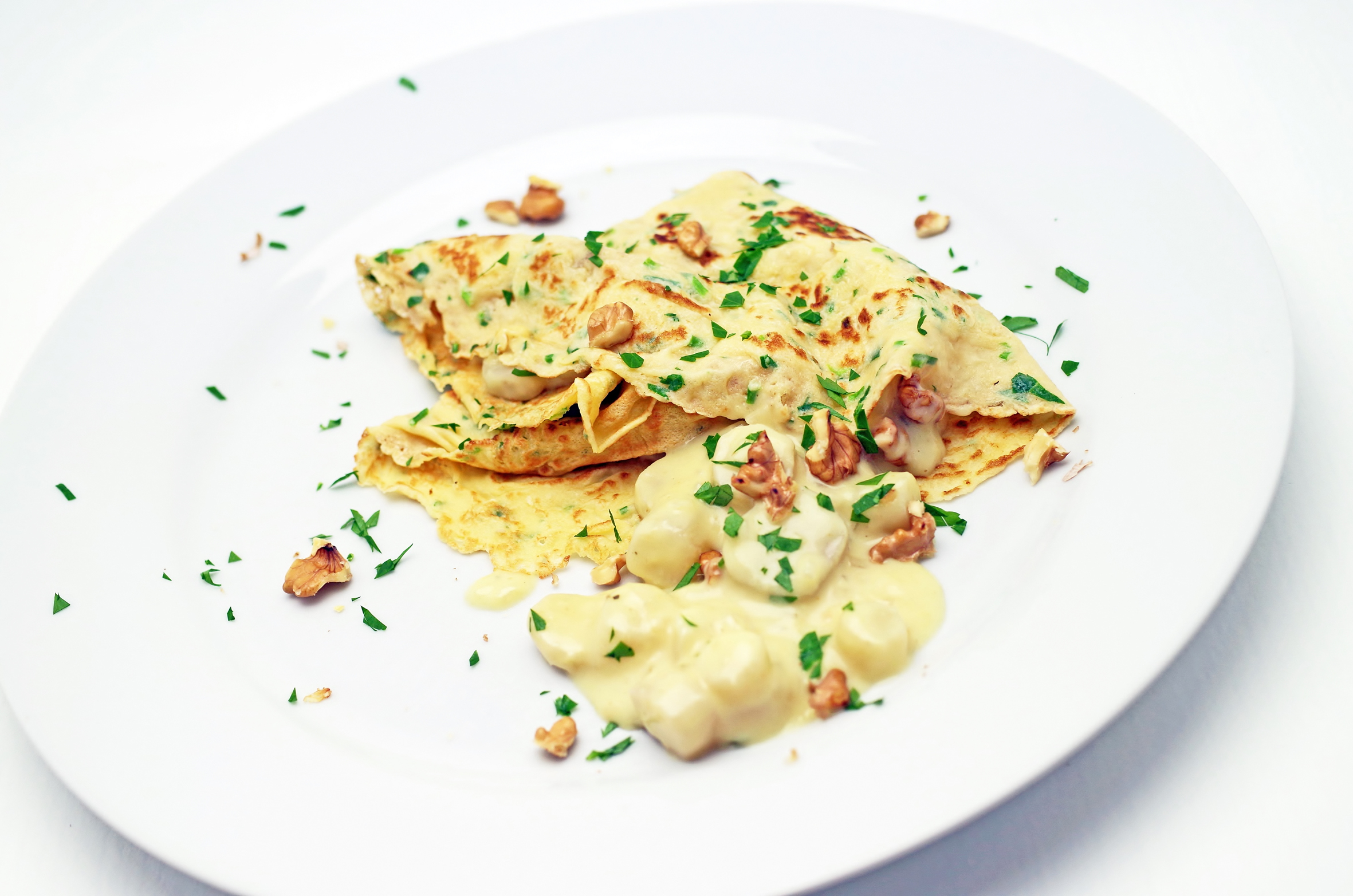 Kräuter-Flädle mit Schwarzwurzel-Ragout gefüllt und gerösteten Walnüssen