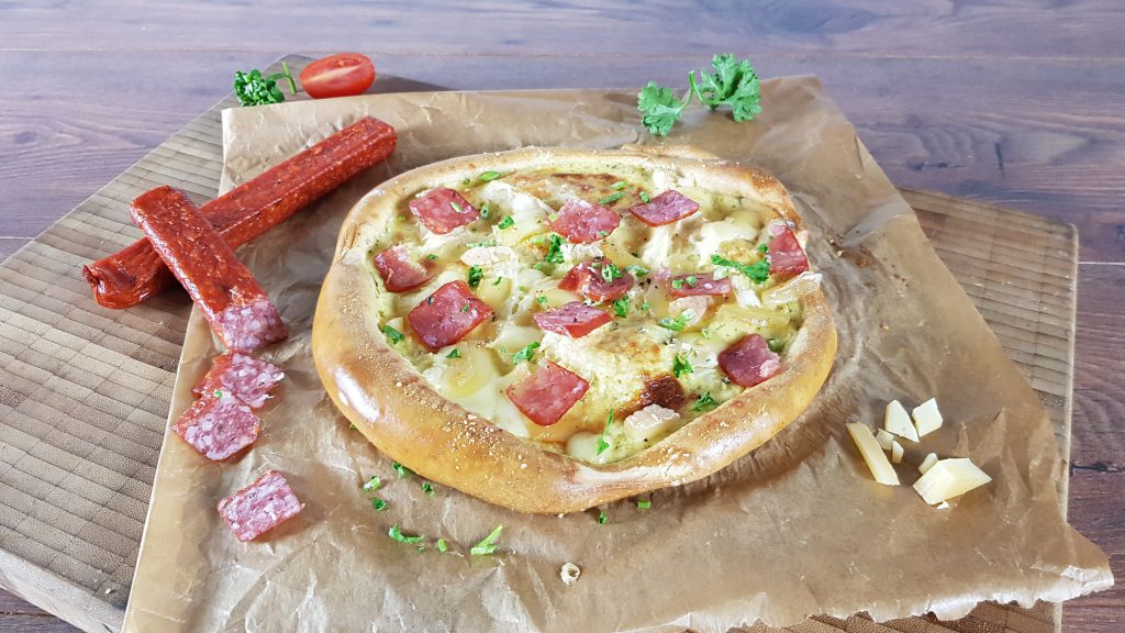 Laugenbrezel-Pizza mit Senfschmand, Sauerkraut, Bergkäse und Landjäger