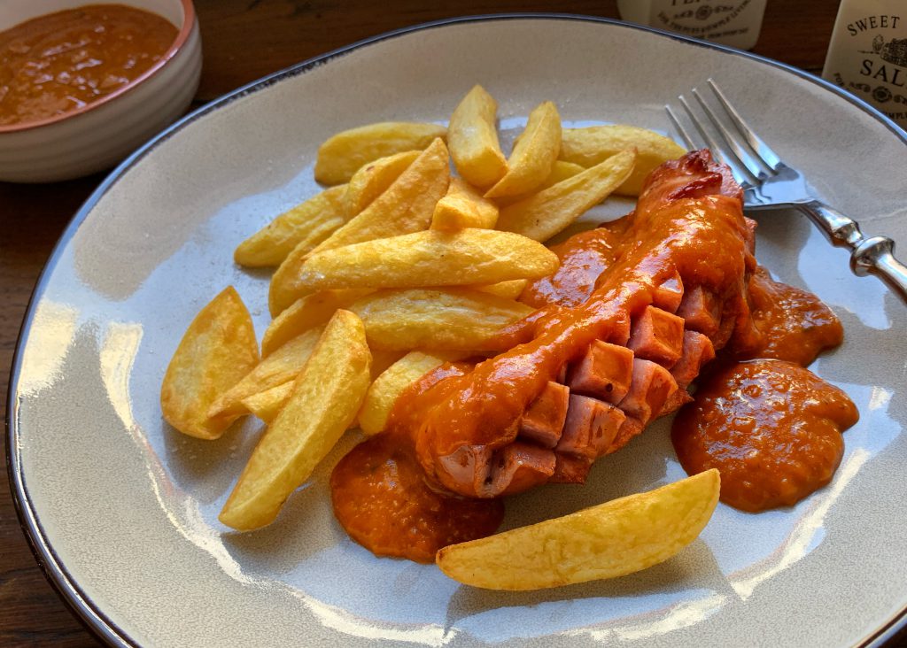 Currywurst mit hausgemachter Currysoße und knusprigen Pommes