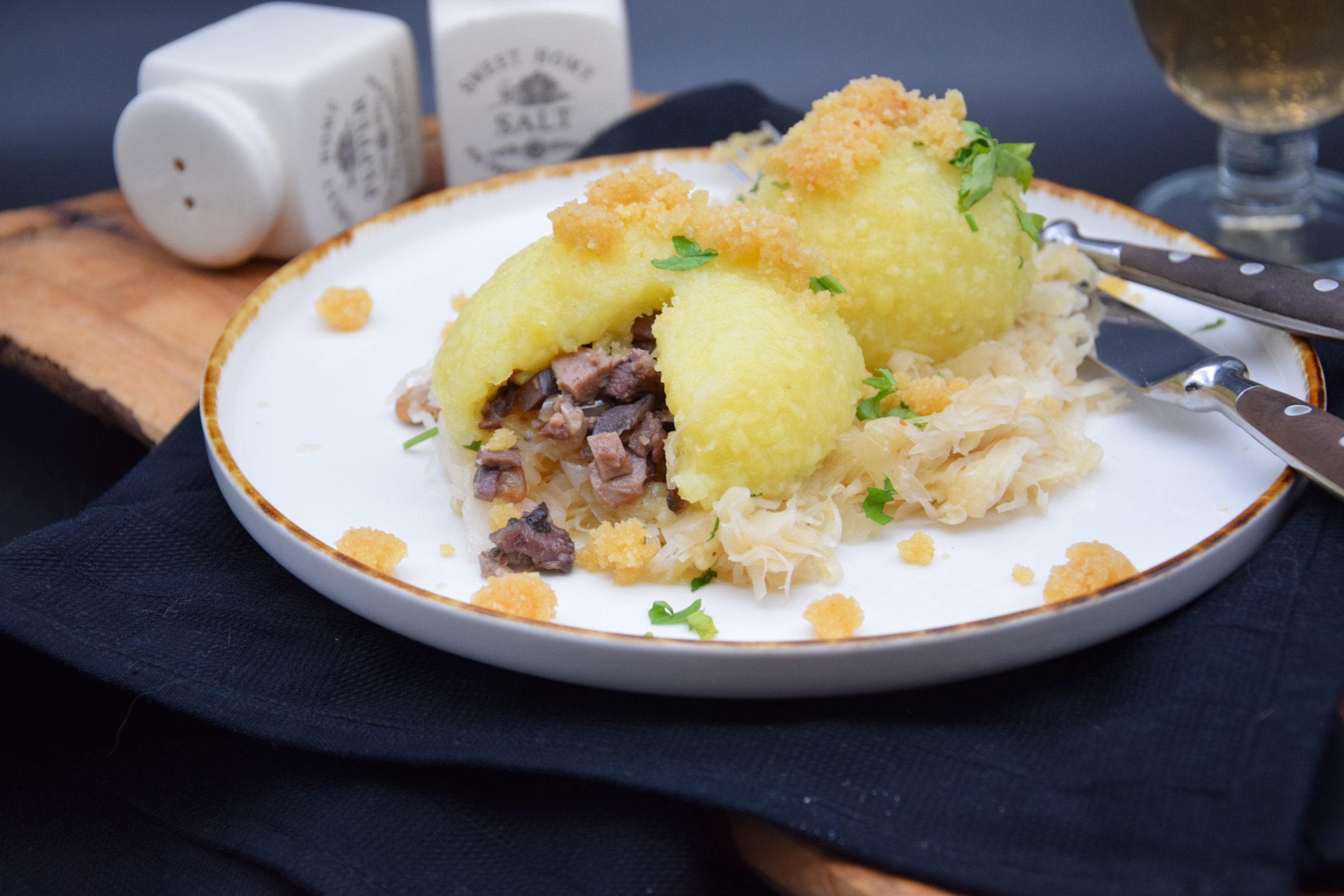 Gefüllte Kartoffelknödel mit Butterbrösel auf Sauerkraut